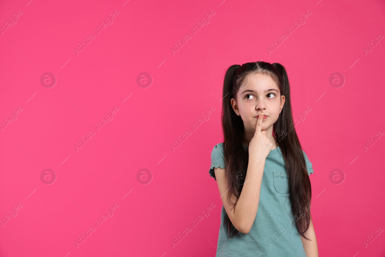 Photo of Pensive little girl on pink background, space for text. Thinking about answer to question