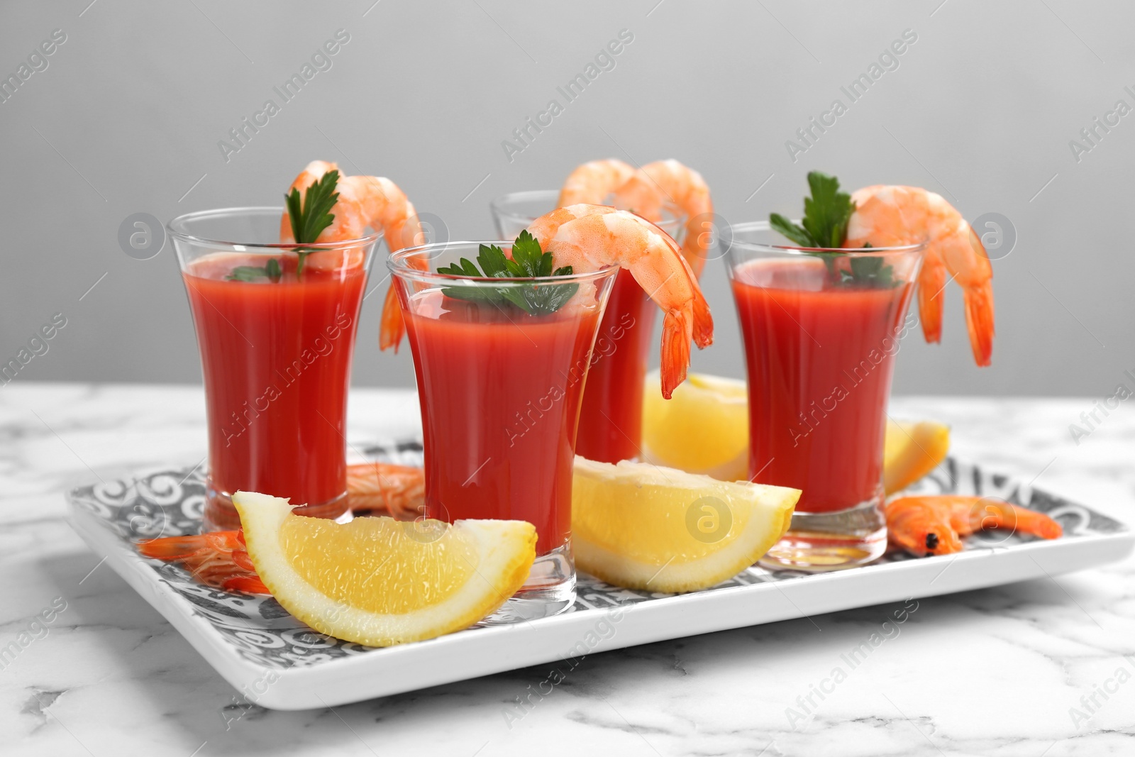 Photo of Shrimp cocktail with tomato sauce served on marble table