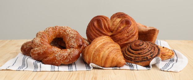 Photo of Different tasty freshly baked pastries on wooden table
