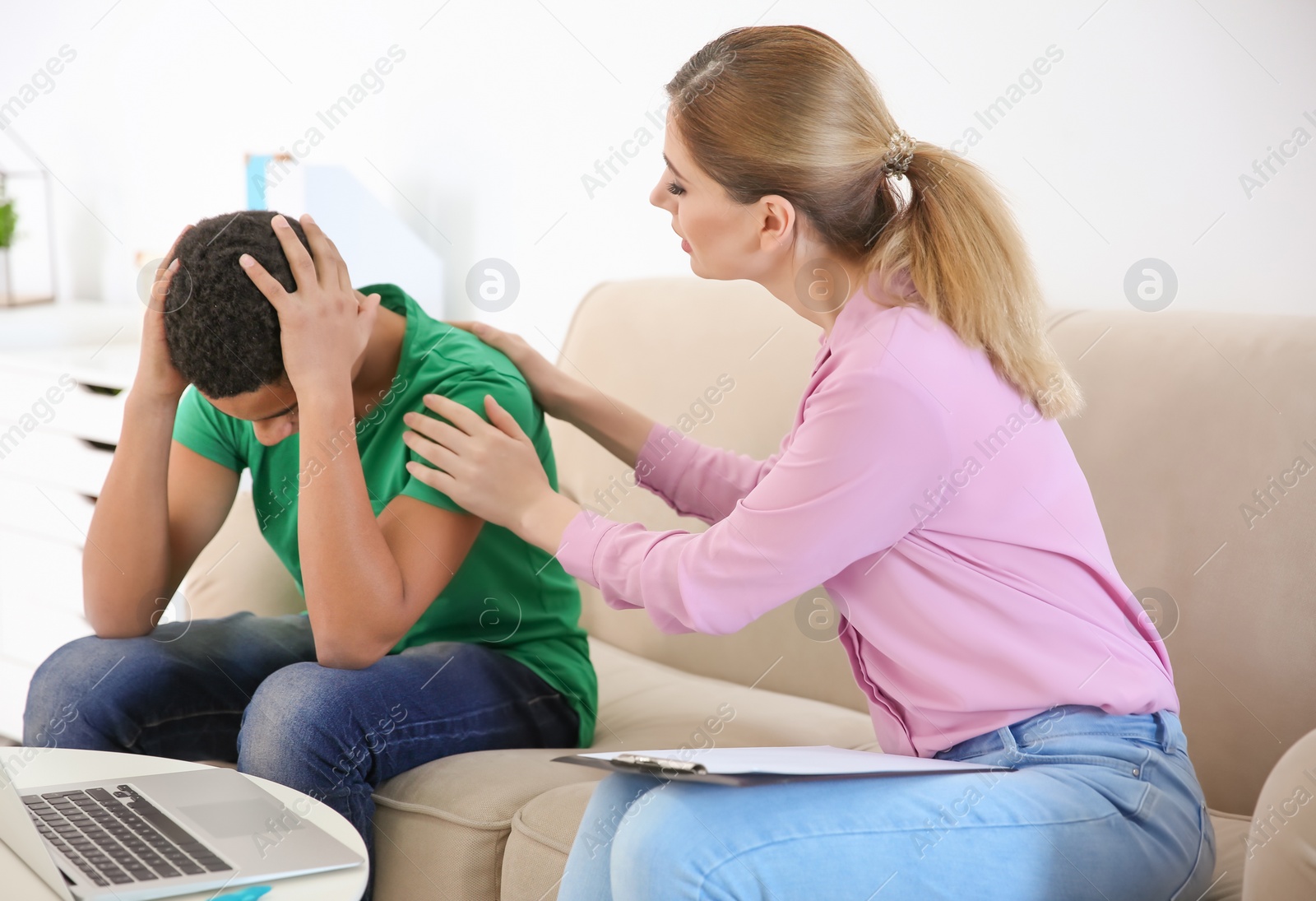 Photo of Female psychologist working with African American teenage boy in office