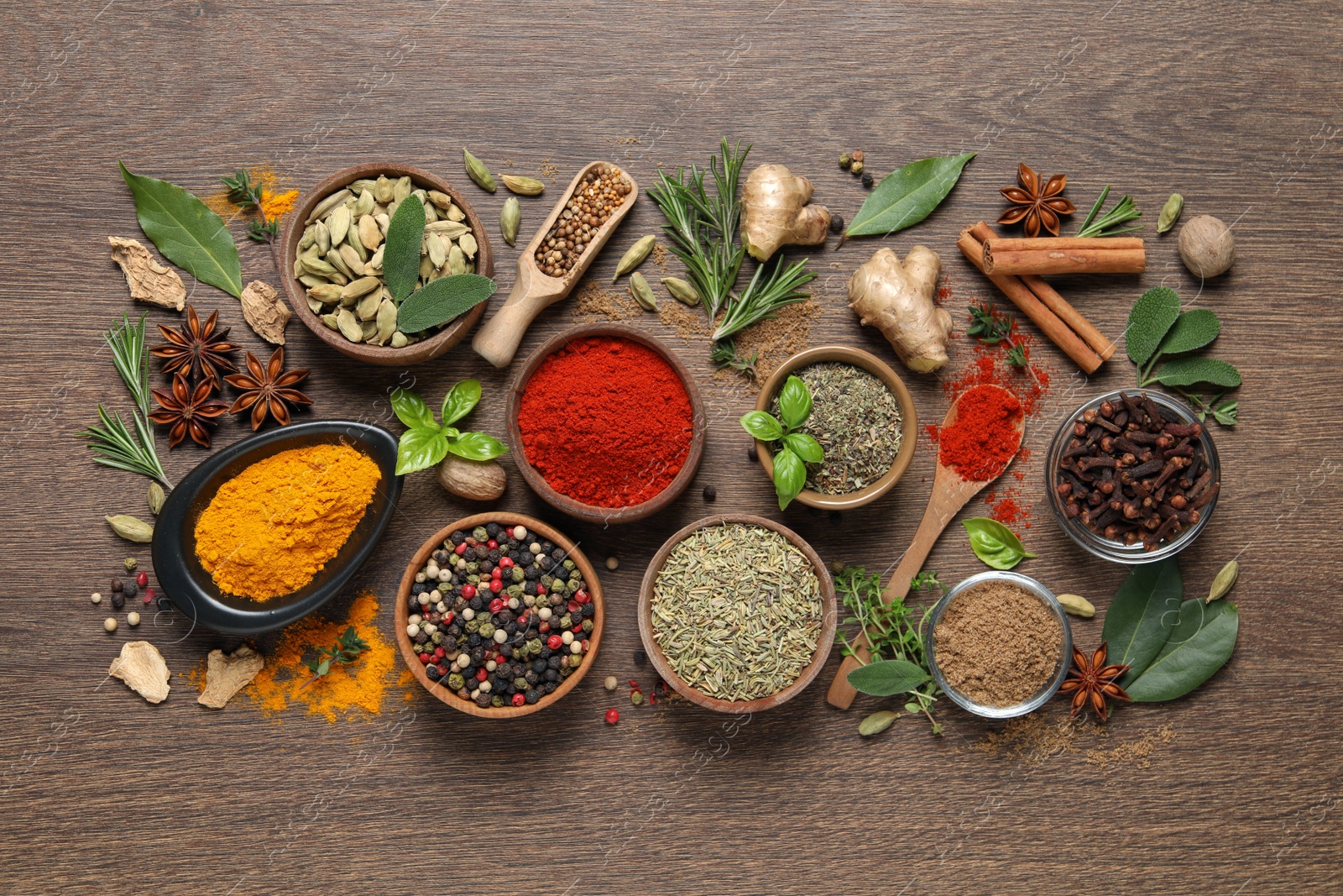 Photo of Different herbs and spices on wooden table, flat lay