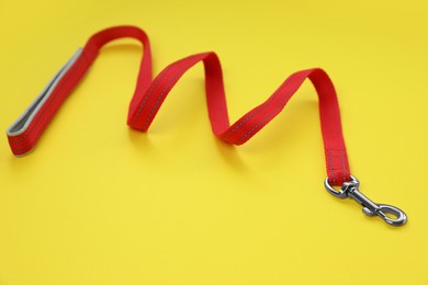 One red dog leash on yellow background