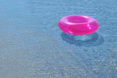 Photo of Bright inflatable ring floating in sea. Space for text