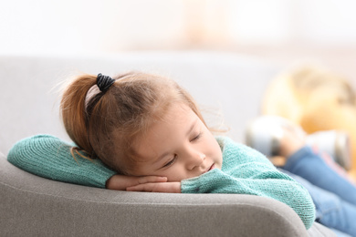 Photo of Cute little girl sleeping on sofa at home