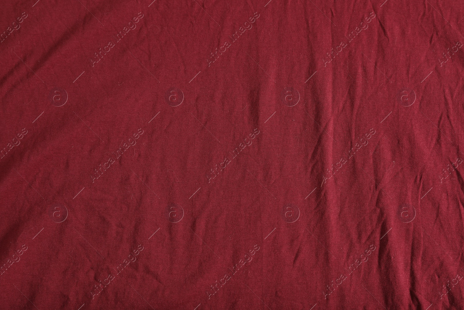 Photo of Crumpled dark red fabric as background, top view