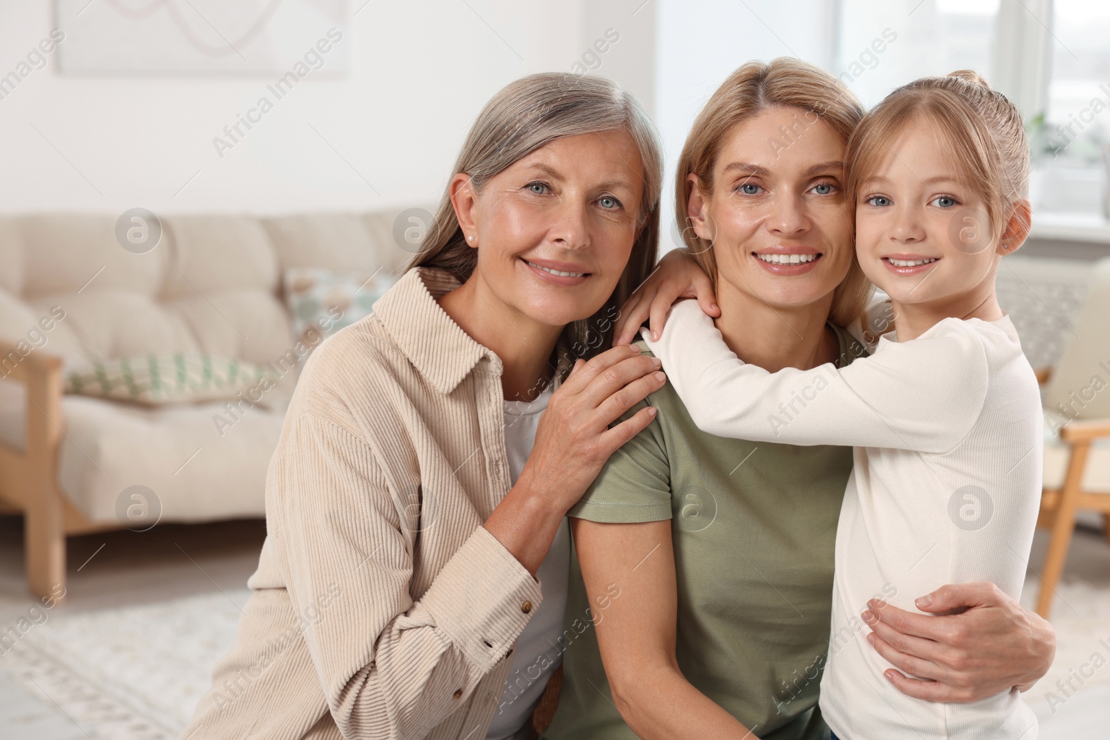 Photo of Three generations. Happy grandmother, her daughter and granddaughter at home