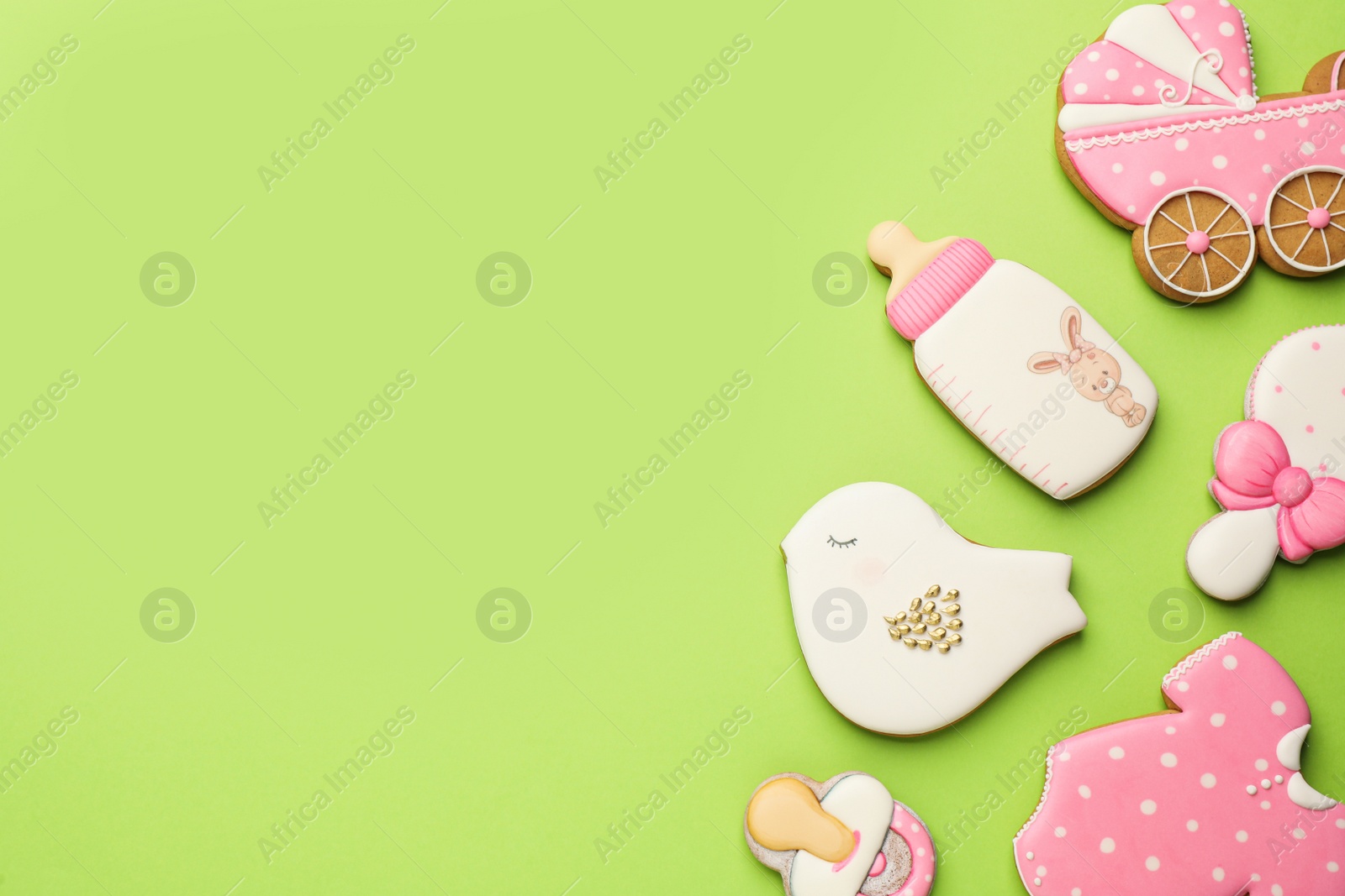 Photo of Cute tasty cookies of different shapes on light green background, flat lay with space for text. Baby shower party