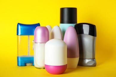 Photo of Set of different deodorants on yellow background