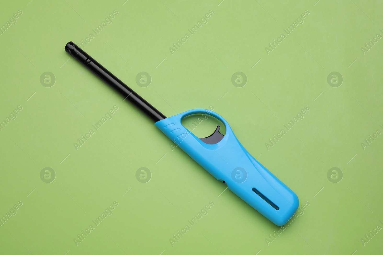 Photo of One gas lighter on green background, top view