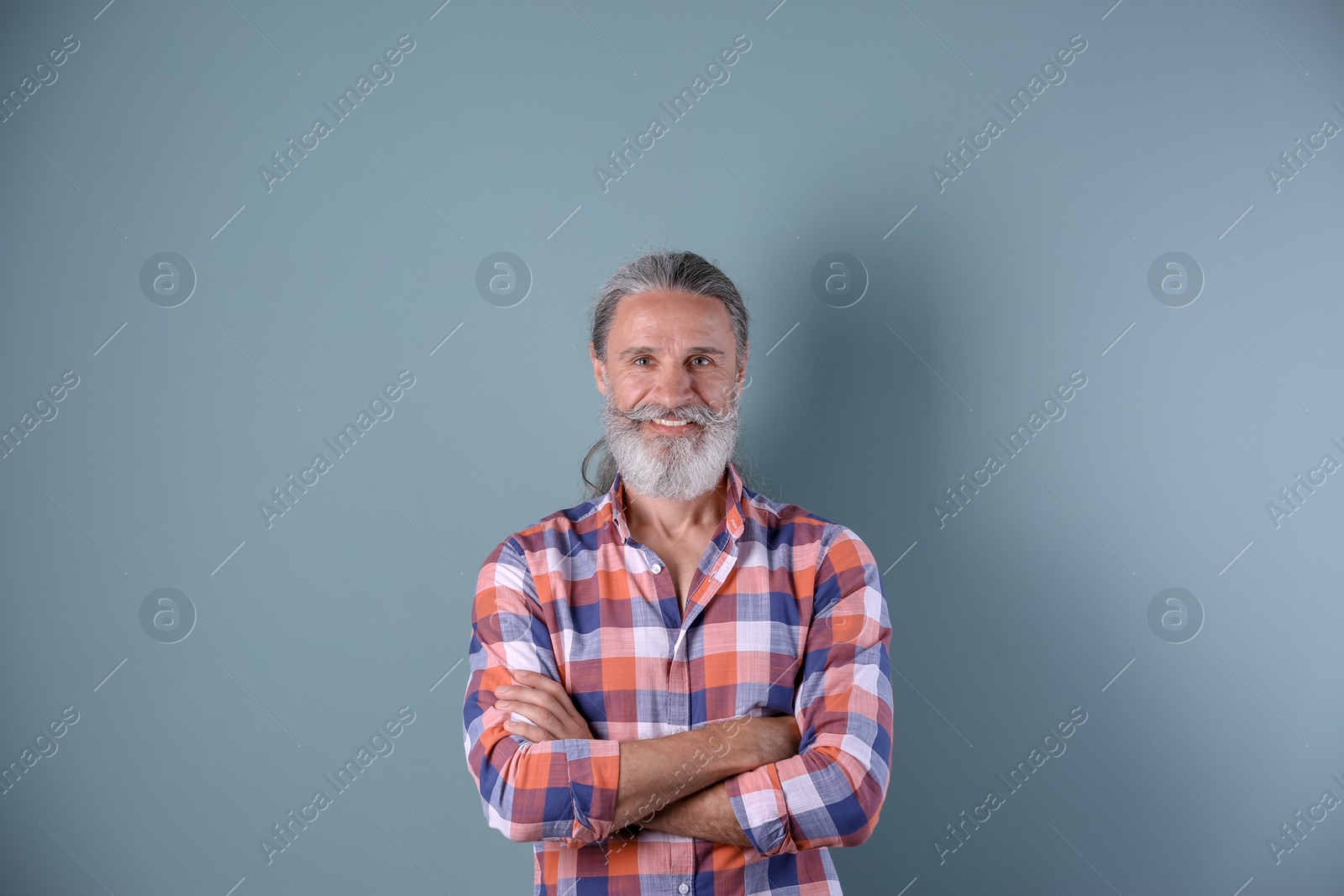 Photo of Handsome bearded mature man on color background