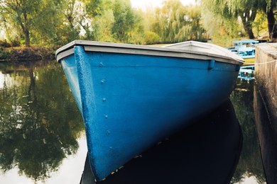 Photo of Light blue wooden boat on lake, closeup