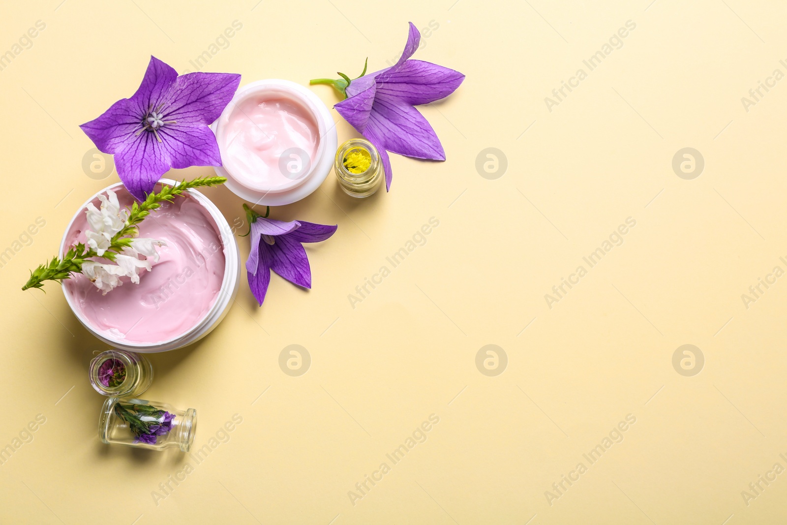 Photo of Flat lay composition with jars of body cream on beige background. Space for text