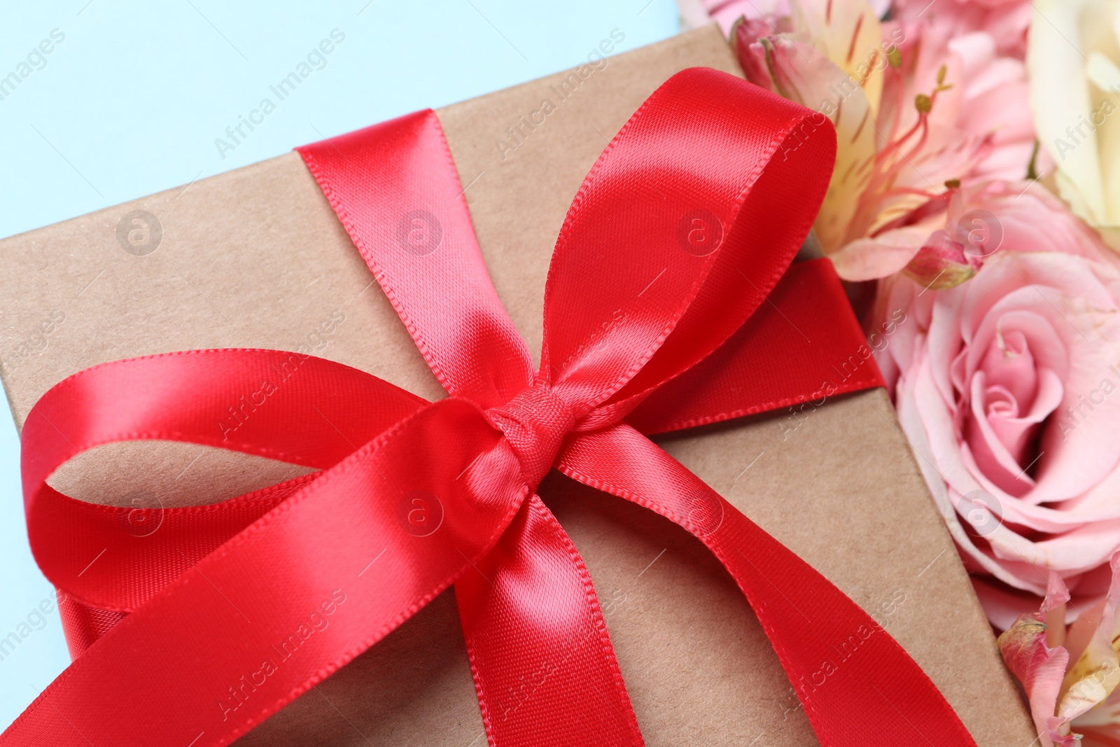 Photo of Gift box and beautiful flowers, closeup view