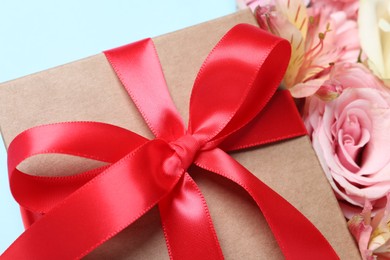 Gift box and beautiful flowers, closeup view