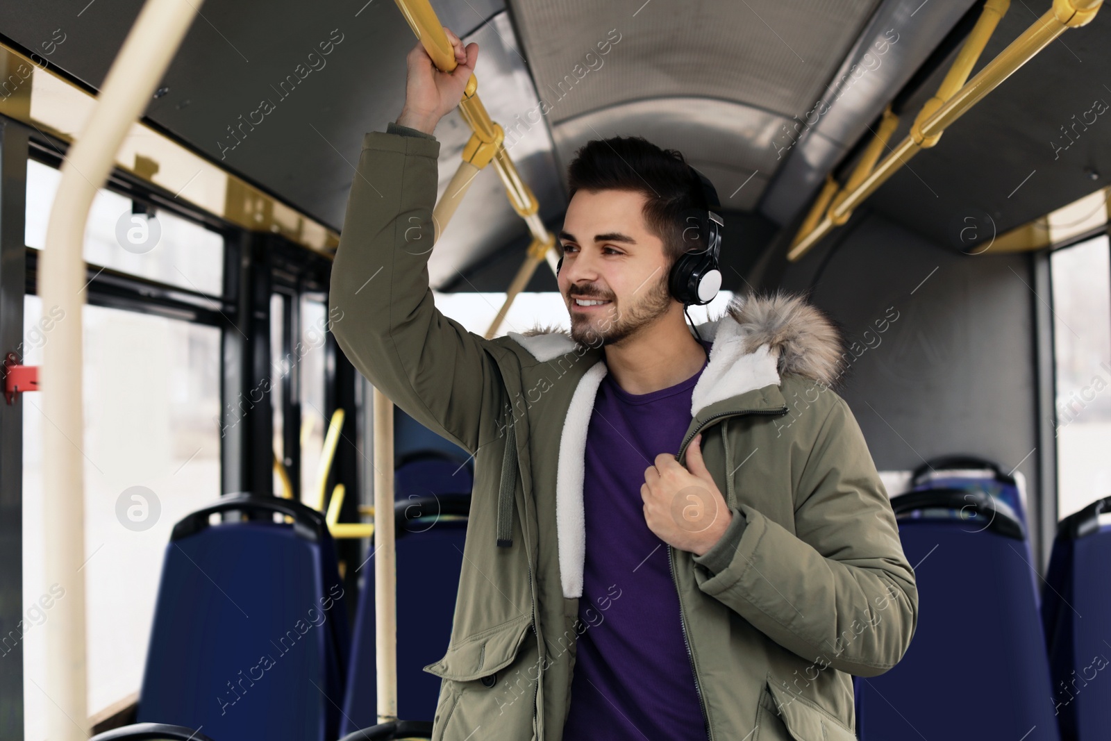 Photo of Young man listening to music with headphones in public transport