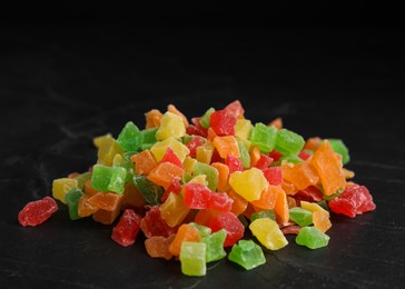 Photo of Mix of delicious candied fruits on black table, closeup