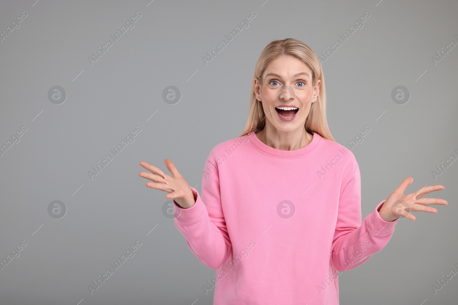 Photo of Portrait of surprised woman on grey background, space for text