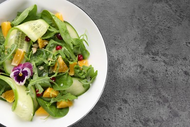 Photo of Delicious salad with cucumber and orange slices on gray table, top view. Space for text