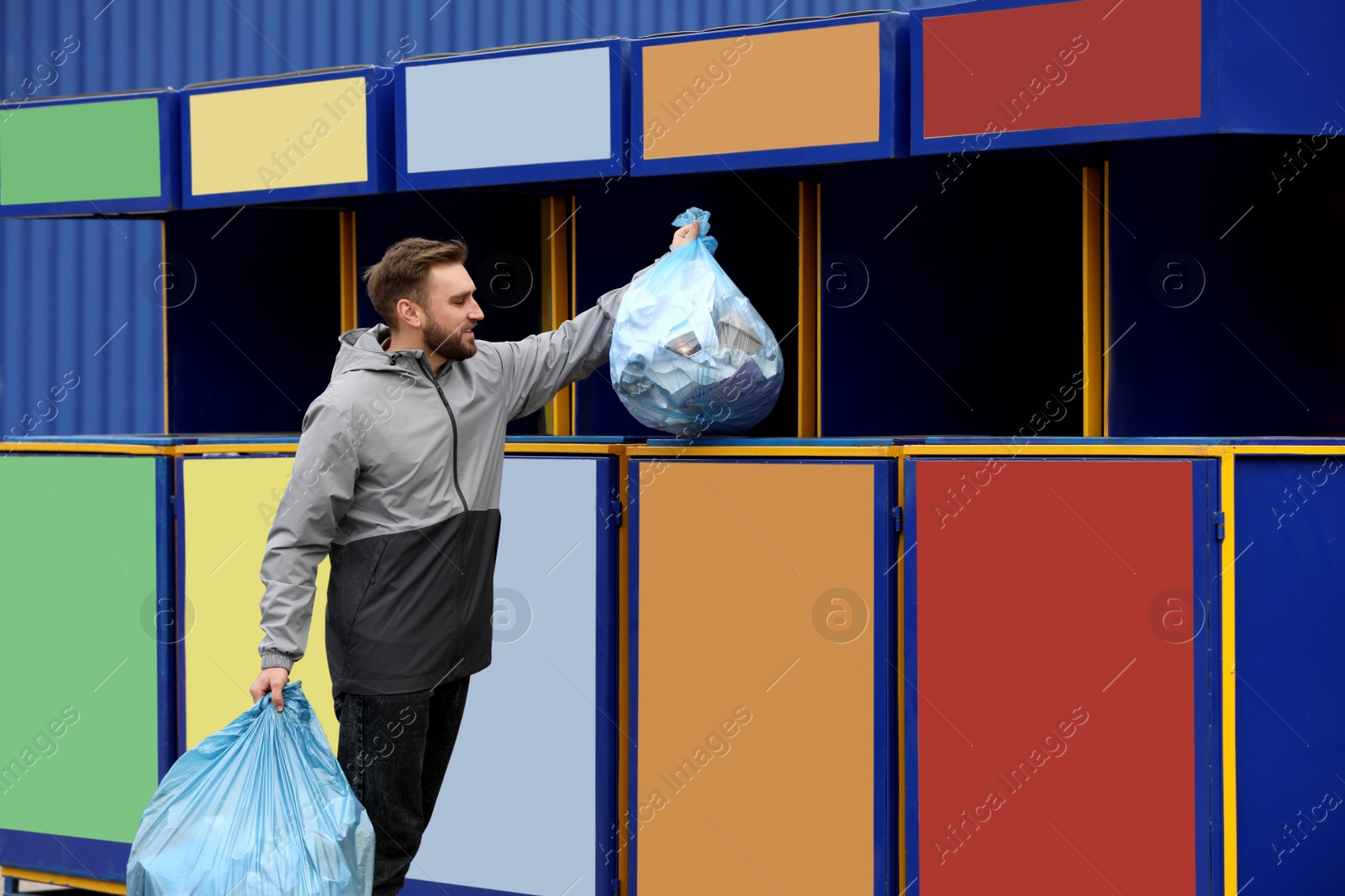 Photo of Man throwing garbage into bin at recycling point outdoors