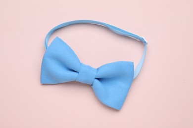 Photo of Stylish light blue bow tie on beige background, top view