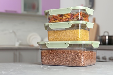 Photo of Stacked boxes with different food on table in kitchen, space for text