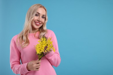 Beautiful young woman on light blue background