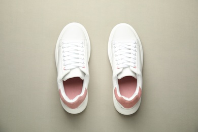 Photo of Stylish white sneakers on grey background, top view