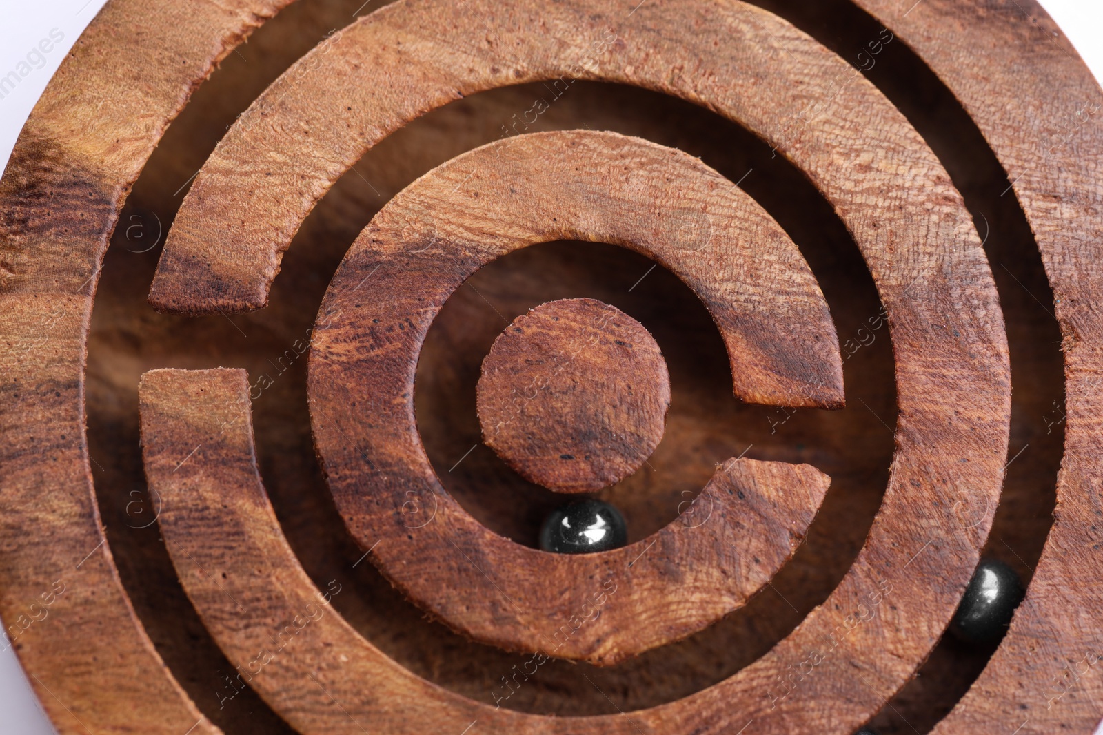 Photo of Wooden toy maze with metal balls, closeup