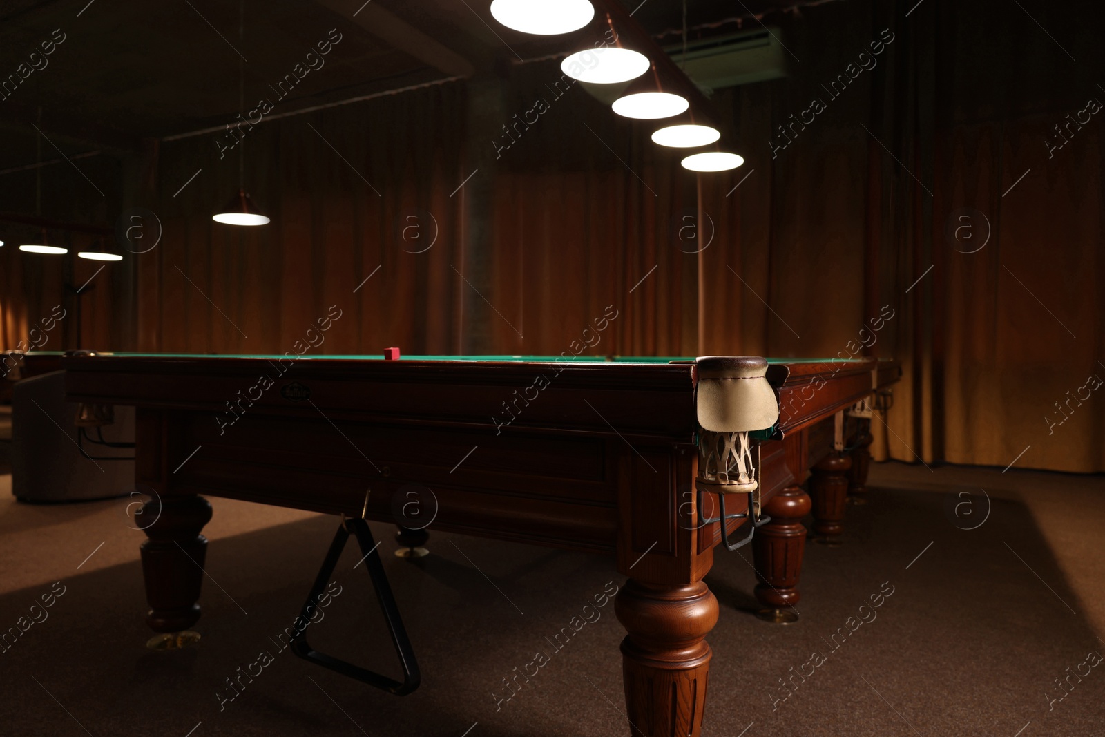 Photo of Piece of red chalk on billiard table indoors