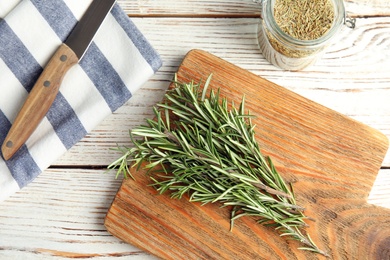 Flat lay composition with fresh rosemary twigs on wooden table