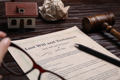 Photo of Last will and testament near house model and gavel on wooden table, closeup