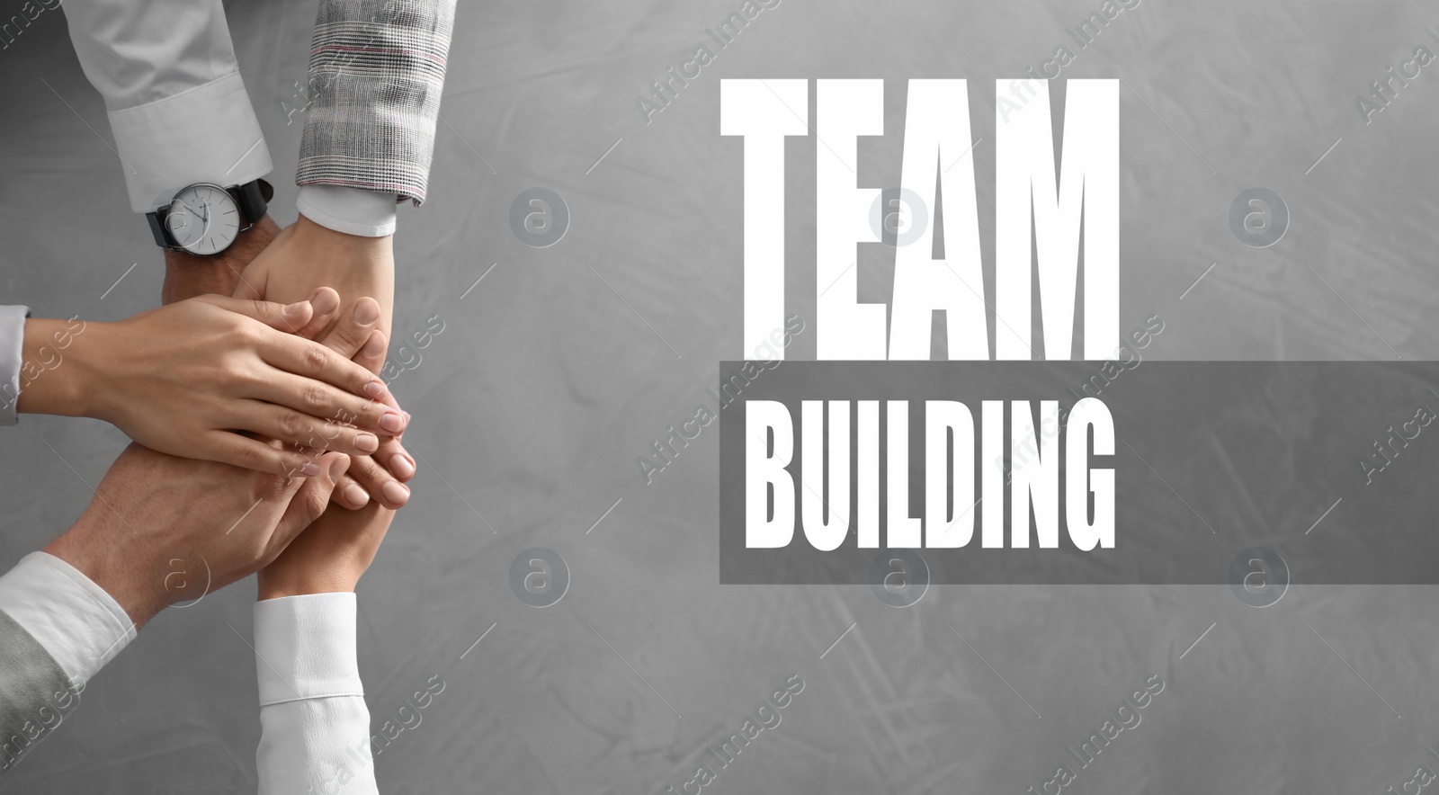 Image of People holding hands together over grey stone background, top view. Team building