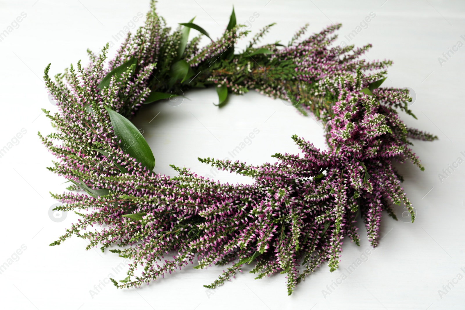 Photo of Beautiful autumnal wreath with heather flowers on white background, closeup