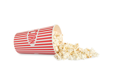 Photo of Overturned paper cup with delicious popcorn isolated on white