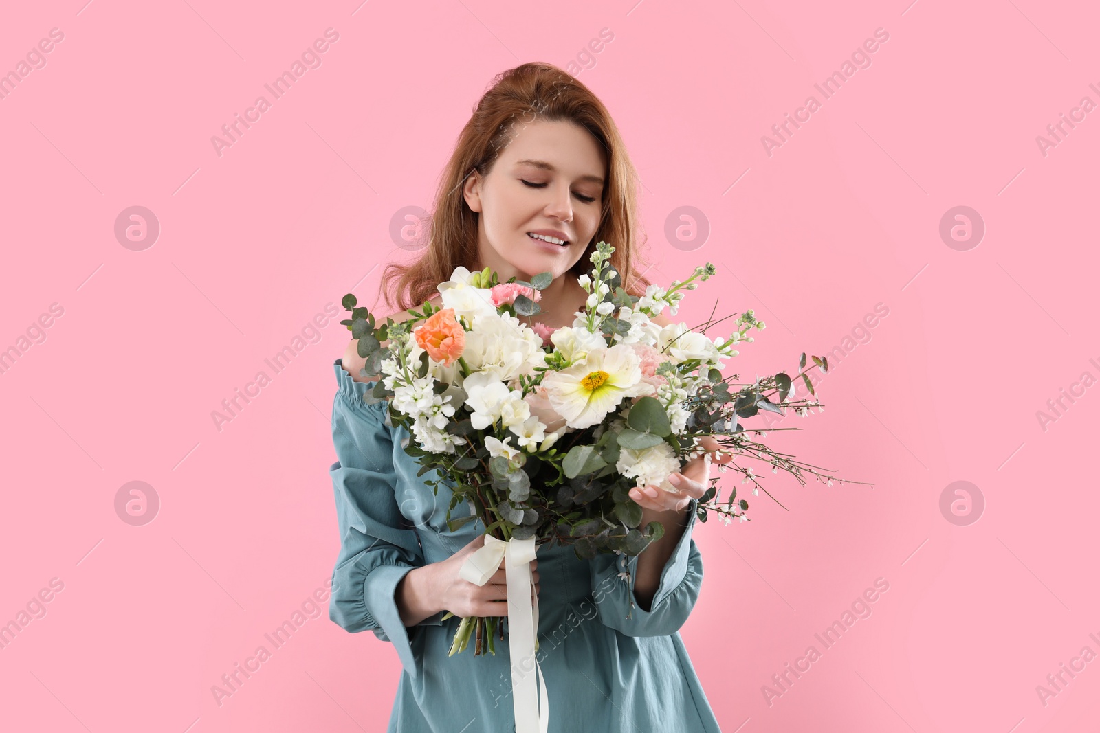 Photo of Beautiful woman with bouquet of flowers on pink background