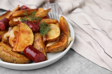 Photo of Delicious baked potato with thin dry smoked sausages, onion and dill on gray table, closeup