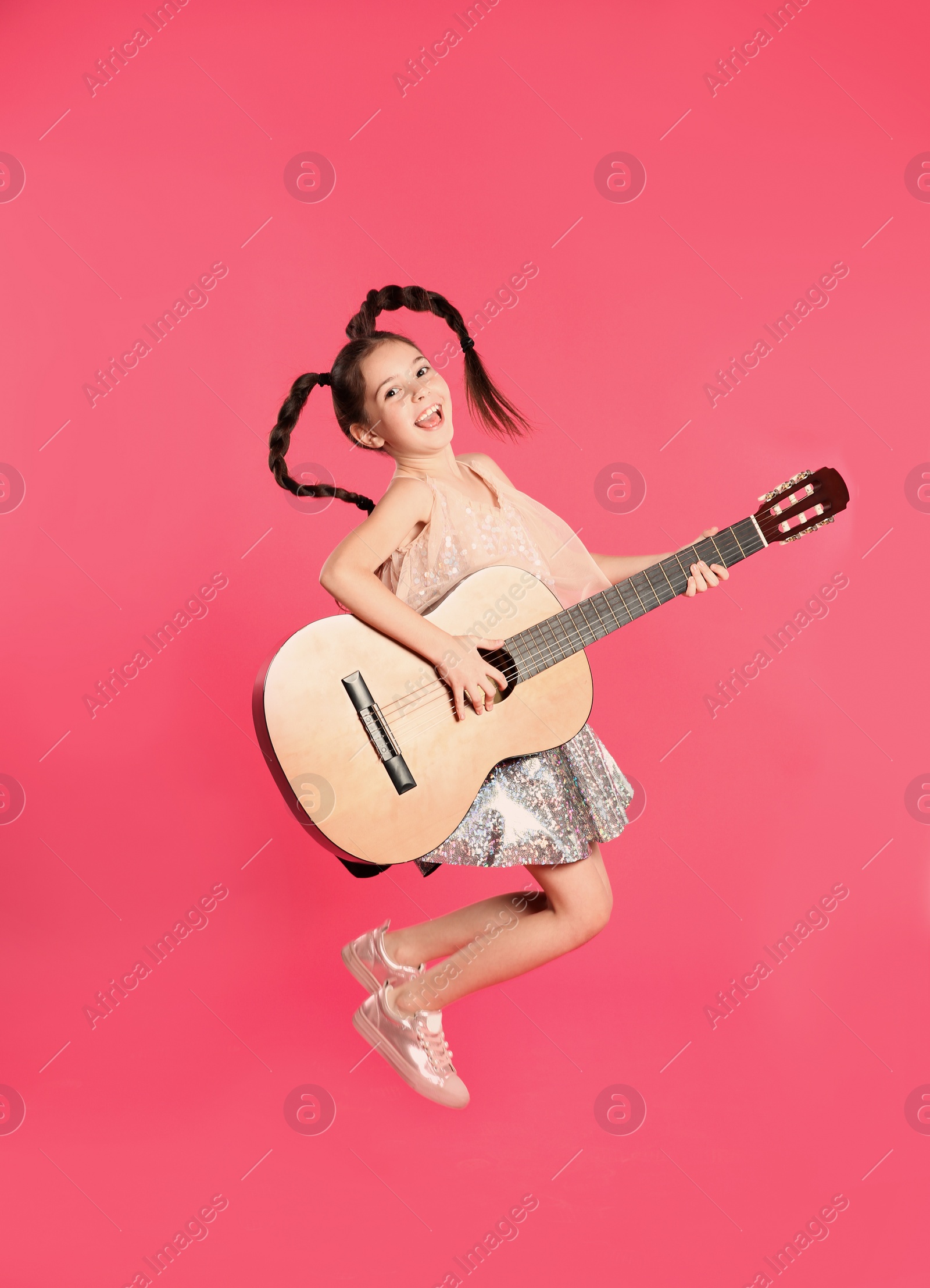 Photo of Cute little girl playing guitar on color background