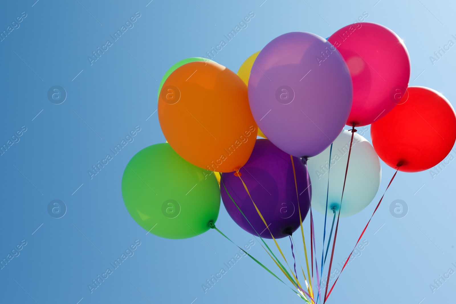 Photo of Bunch of colorful balloons against blue sky