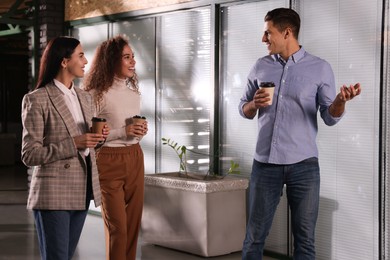 Group of coworkers talking during coffee break in office