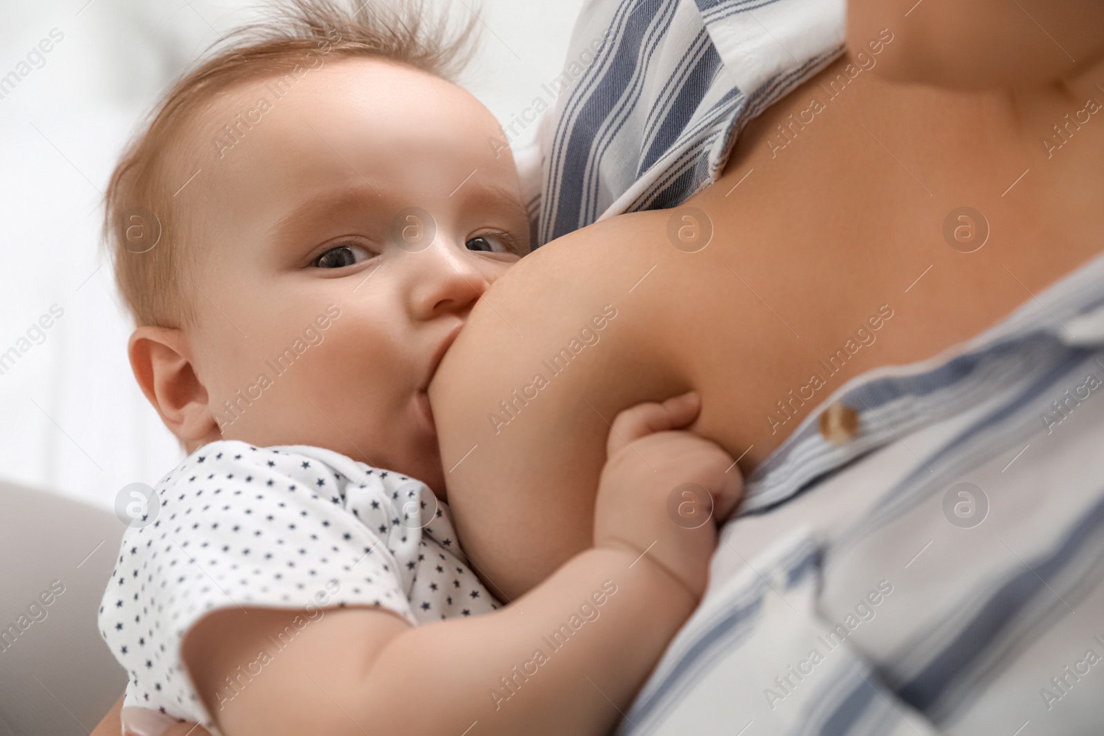 Photo of Woman breastfeeding her little baby at home