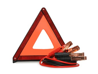 Emergency warning triangle and battery jumper cables on white background. Car safety