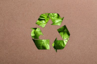 Recycling symbol made of green leaves on kraft paper