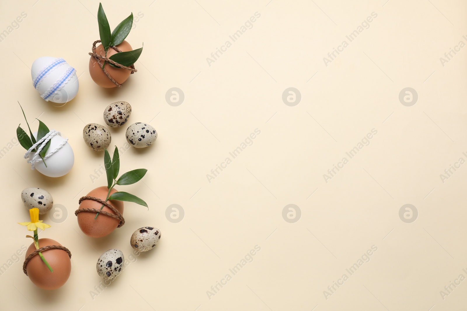 Photo of Festively decorated Easter eggs on beige background, flat lay. Space for text