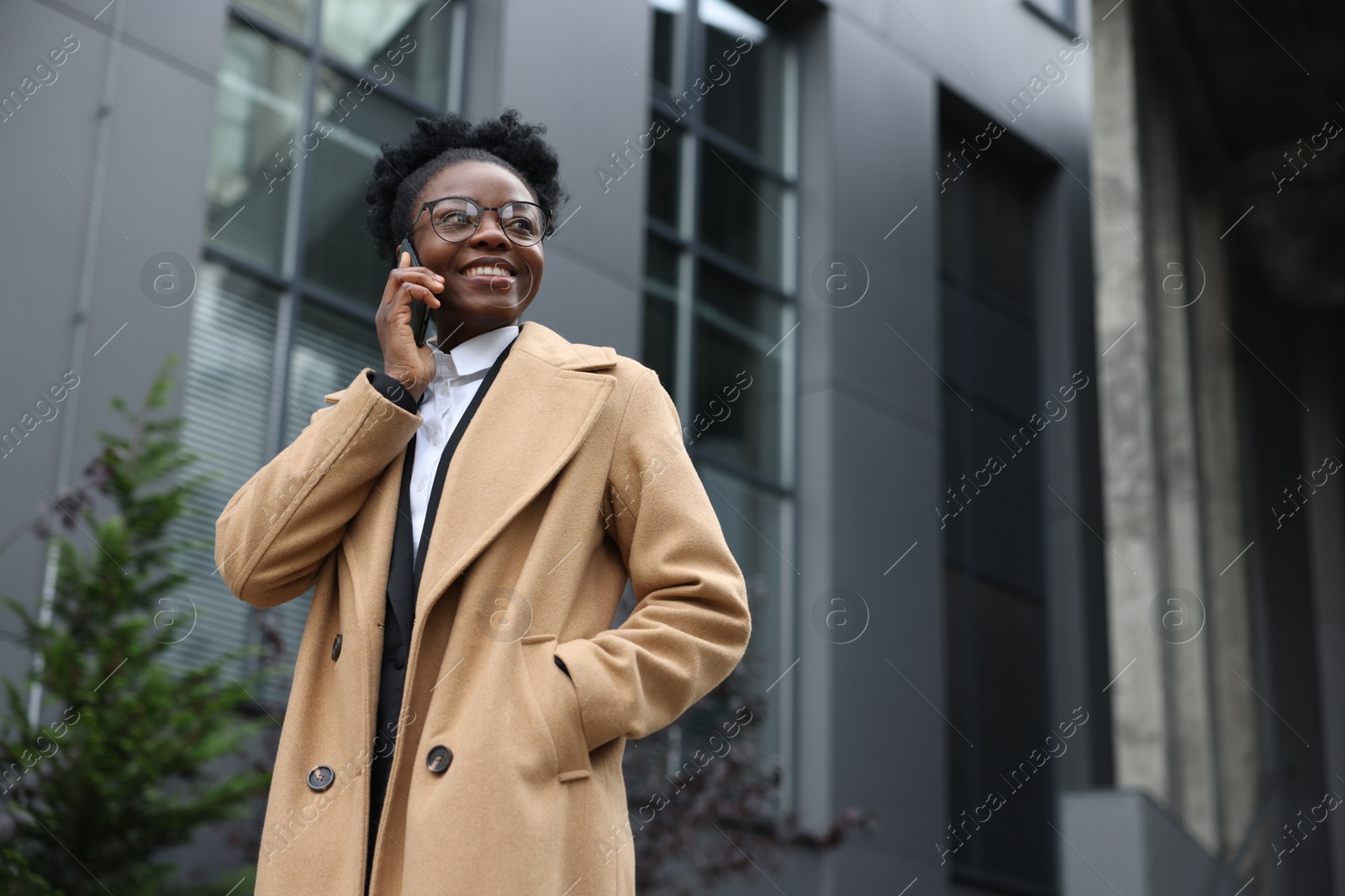Photo of Happy woman talking on smartphone outdoors, space for text. Lawyer, businesswoman, accountant or manager
