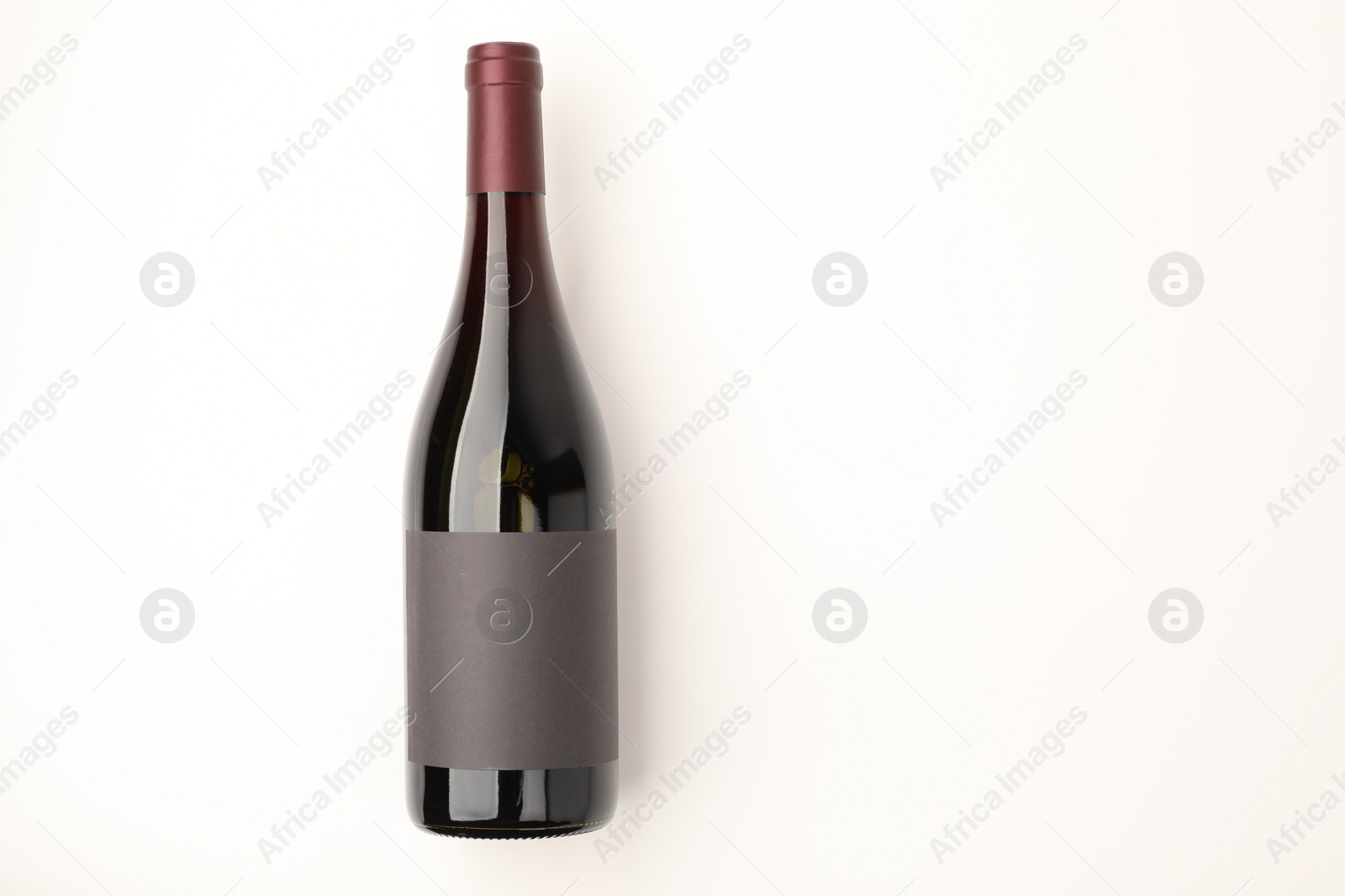 Photo of Bottle of tasty red wine on white background, top view. Space for text