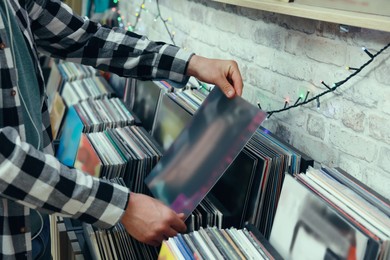 Man choosing vinyl records in store, closeup