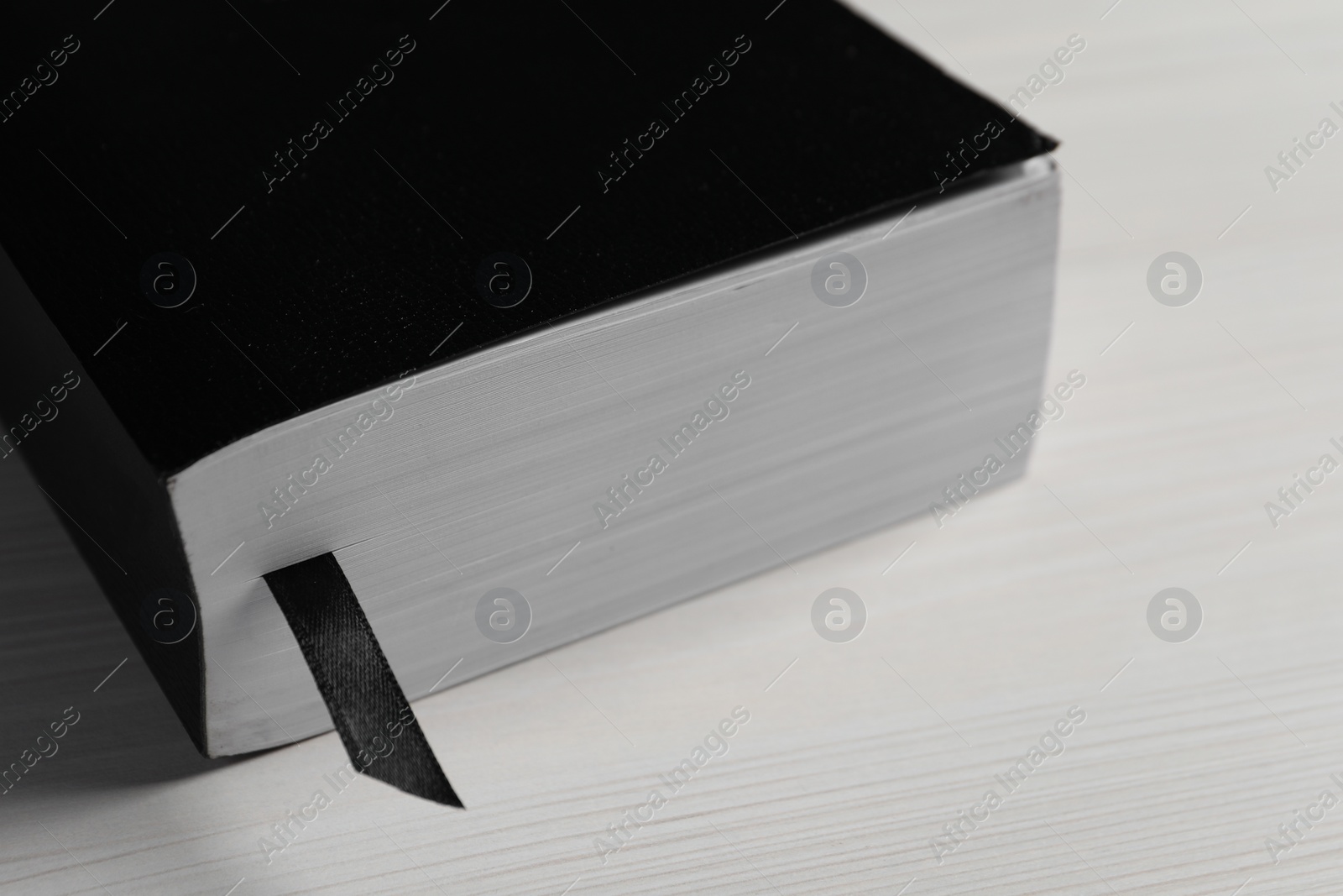 Photo of Holy Bible on white wooden table, closeup