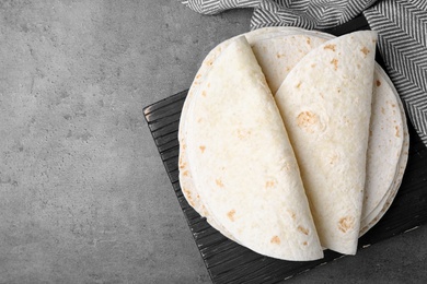 Photo of Corn tortillas on grey background, flat lay with space for text. Unleavened bread