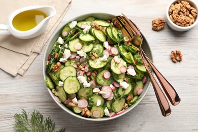 Photo of Delicious cucumber salad served on white wooden table, flat lay