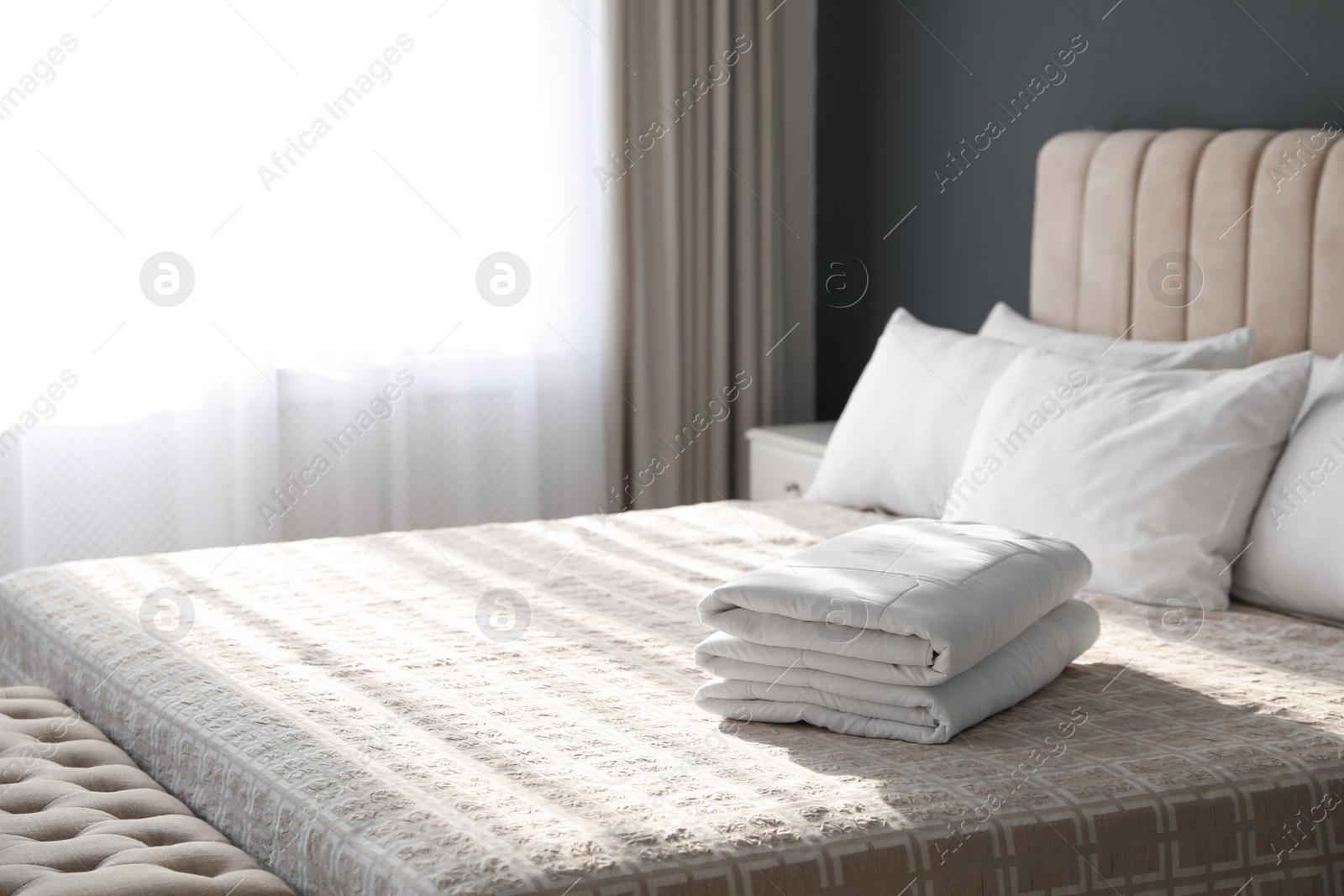 Photo of Folded clean blanket on bed in room. Space for text